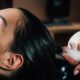 Deep conditioning hair treatment being performed on young lady