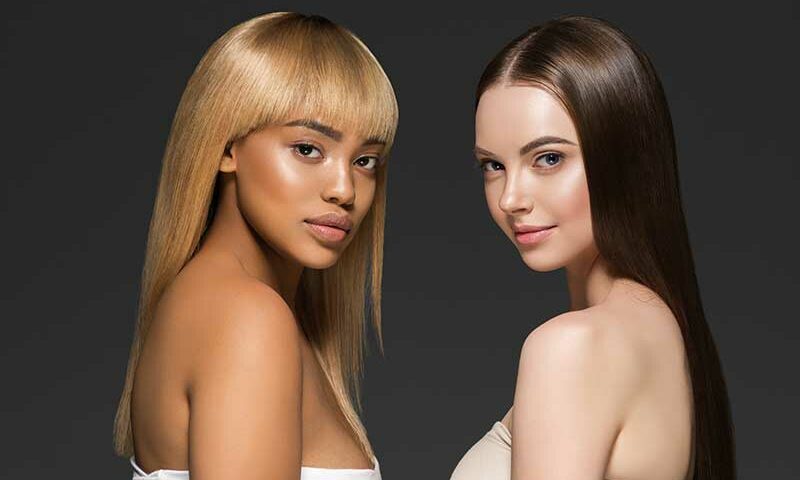 Two Women wearing Wigs to show the Key Differences Between Synthetic and Human Hair Wigs